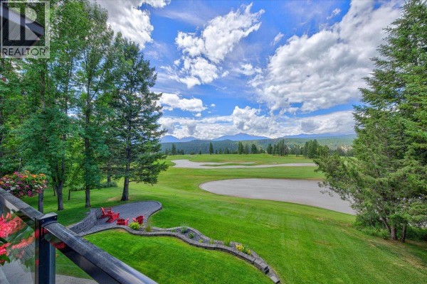 Covered patio with wicker furniture and red cushions, overlooking the front entrance. - 7495 Sun Valley Place, Radium Hot Springs