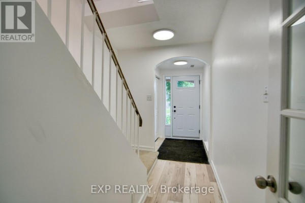 Bedroom with light wood laminate flooring, white walls, and mirrored closet doors. - 75 - 90 Lightfoot Place, Ottawa