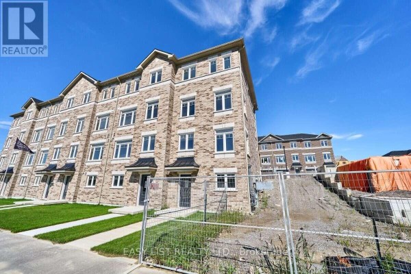 Exterior view of brick townhouse complex with construction site on the right. - 75 Addyman Crescent, Clarington