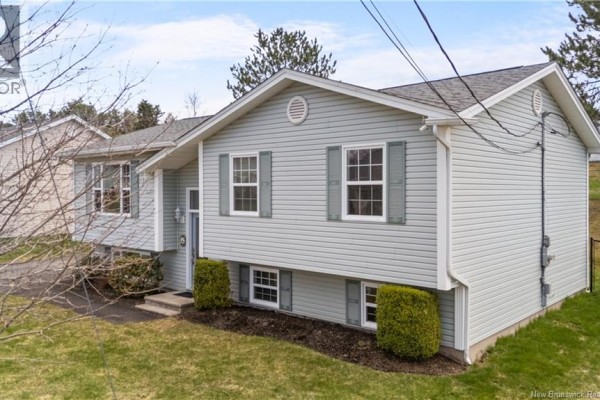 Right side exterior view of a light blue split-level house with white trim and gray shutters. - 75 Anik, Dieppe