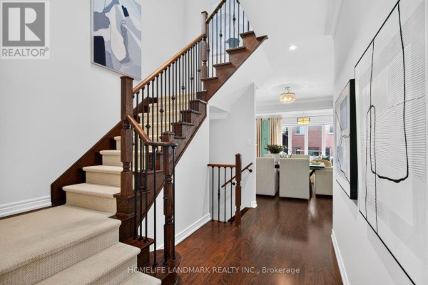 Interior foyer with a dark wood staircase, beige carpeted steps, and dark hardwood floors. - 75 Estrella Crescent, Richmond Hill