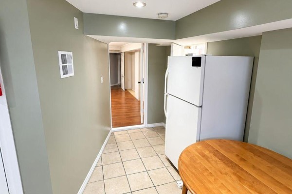 Compact kitchen area with beige tiled floor and white refrigerator. - 75 Kootenay Crescent, Toronto