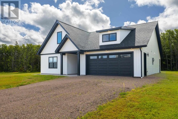 Modern white house with attached garage, gravel driveway, and white siding. - 75 Oceanlinks Lane, West St  Peters
