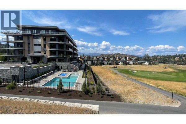 Side view of the apartment building highlighting its modern design and landscaping features. - 75 Predator Ridge Drive Unit# 107, Vernon