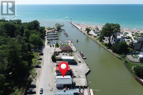 Aerial view of waterfront buildings along a canal leading to the ocean. - 75 River Road, Lambton Shores