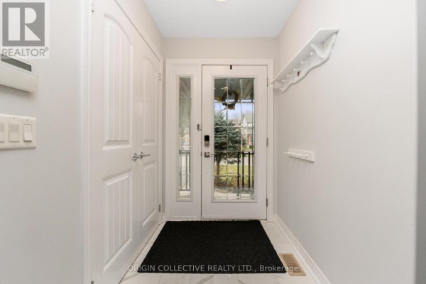 Interior entryway with white doors, glass-paneled front door, and black doormat on tiled floor. - 75 Sheffield Street, Southgate