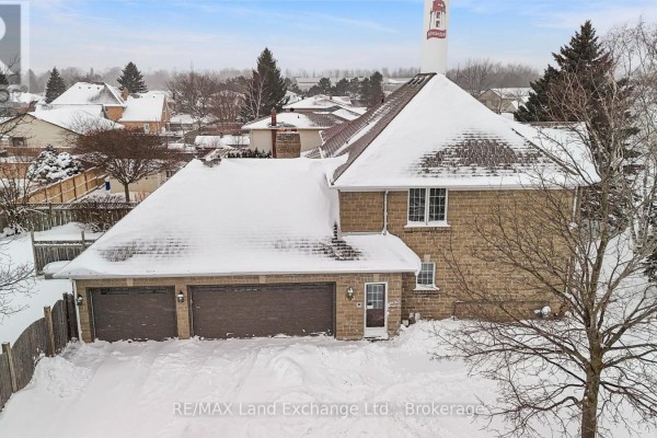Aerial view of the house with snow-covered roof, large garage, and surrounding residential area. - 750 Mcpherson Crescent, Kincardine