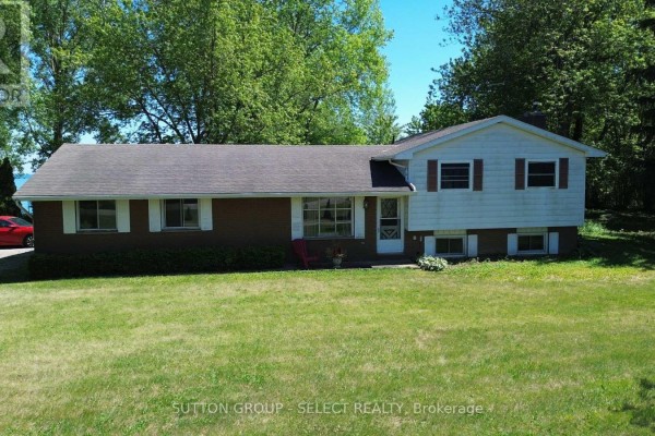 Exterior view of a large gray building with multiple windows under a clear blue sky. - 7504 Talbot Trail, Chatham Kent