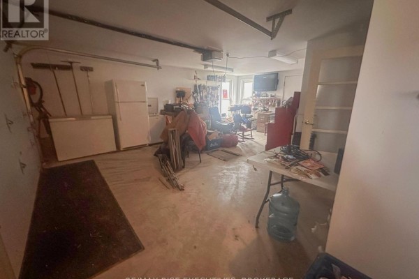 Kitchen with wood cabinets, a dining table with chairs, and a door to the outside. - 7537 County Rd 2, Greater Napanee