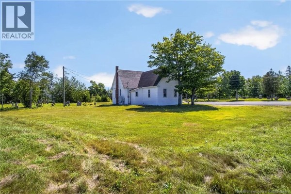 Side view of the white church with a grassy field and trees. - 7538 Route 102, Browns Flat