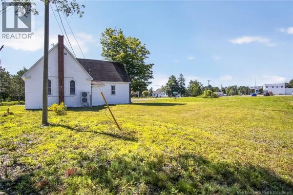 Rear exterior of the white church with an air conditioning unit and field. - 7538 Route 102, Browns Flat