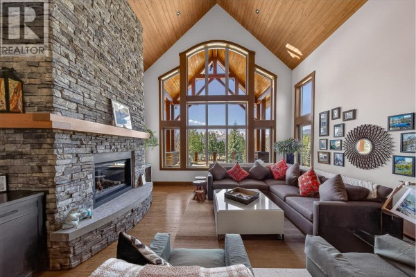 Interior entryway with wood stairs, stone accent wall, wooden bench with plaid blanket, and tiled floor. - 7540 Springs Terrace, Radium Hot Springs