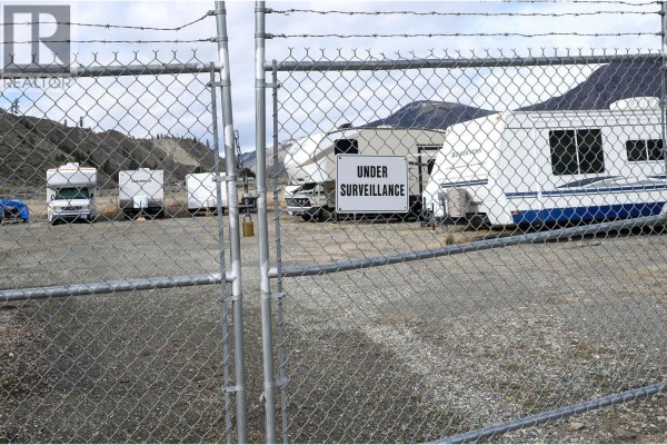 Storage lot with RVs and trailers behind a chain-link fence. - 7545 Dallas Drive Unit# 54, Kamloops