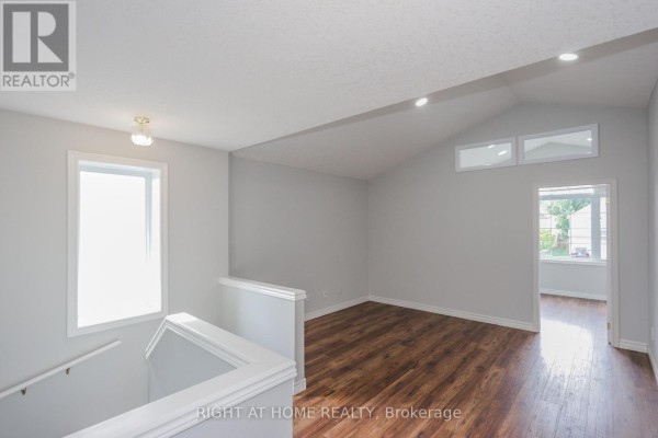 Hallway at the top of the stairs with wood floors and vaulted ceiling. - 756 Hedgerow Place, London North