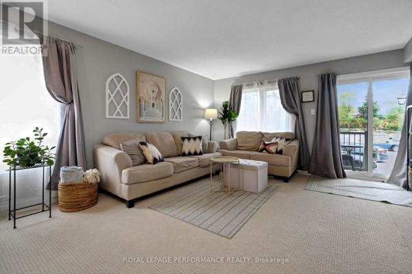 Living room with neutral-colored furniture, grey curtains, and a sliding glass door. - 76 Argent Private, Ottawa