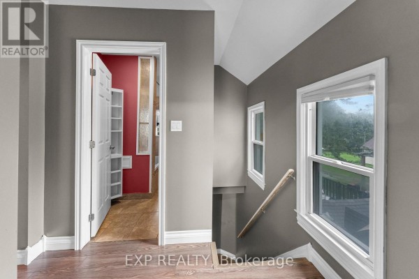 Hallway with built-in shelves, staircase, and windows - 76 Bell Street Port Colborne