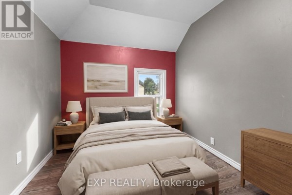 Bedroom with vaulted ceiling, bed, lamps, and artwork - 76 Bell Street Port Colborne