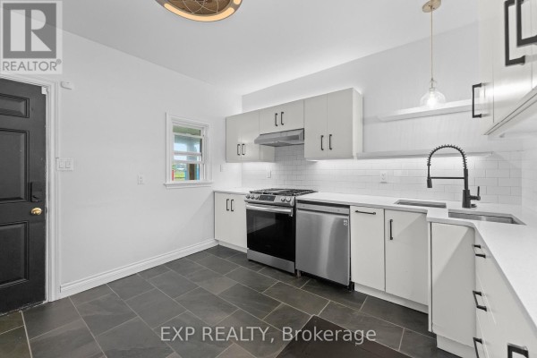 Modern kitchen with stainless steel appliances, white cabinets and tile backsplash - 76 Bell Street Port Colborne