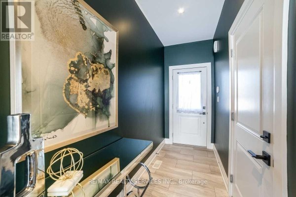 Entryway with dark green walls, wood-look tile floor, and a large abstract wall painting. - 76 Burton Street, Hamilton