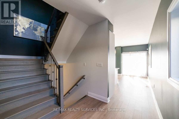 Interior staircase with gray wood treads and risers, and dark metal railings. - 76 Burton Street, Hamilton