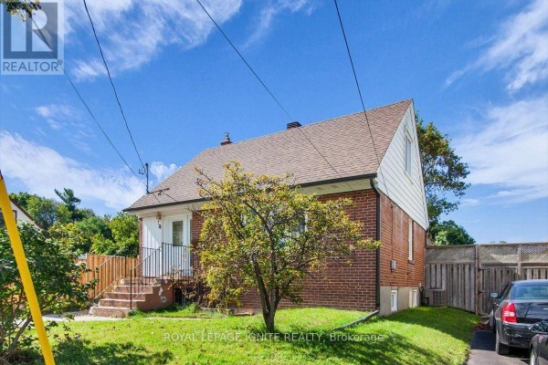 Side view of a detached red brick house with a pitched brown roof and fenced backyard. - 76 Celeste Drive, Toronto