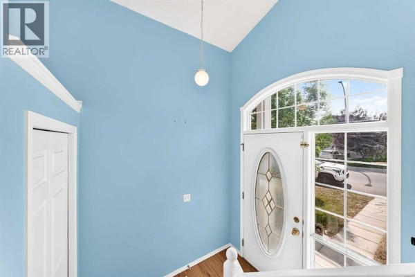 Interior view of the home entrance with light blue walls and a white door. - 76 Coville Close Ne, Calgary