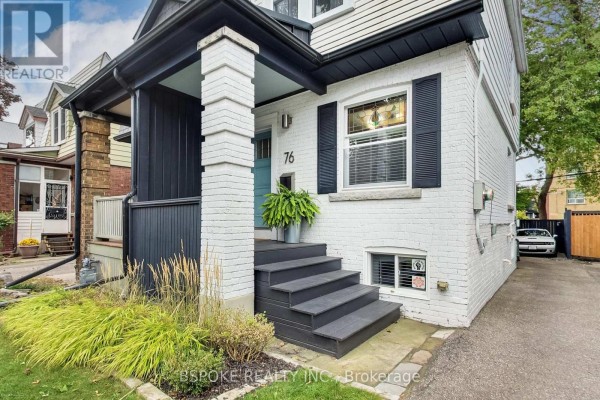 Close-up of the front steps and entrance of a white brick house with black shutters. - 76 Hiltz Avenue, Toronto