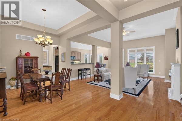 Open-concept living and dining area with hardwood floors, a wooden dining set, and a living room set. - 76 Mcdermott Trail, Stouffville