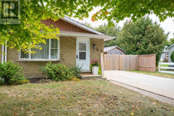 Close-up of the front entrance to a beige brick bungalow with a white door and porch. - 761 Arlington Street, Saugeen Shores