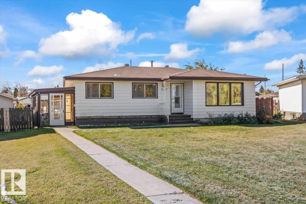 Front exterior of a white bungalow with a covered porch and large windows. - 7627 128a Av Nw, Edmonton