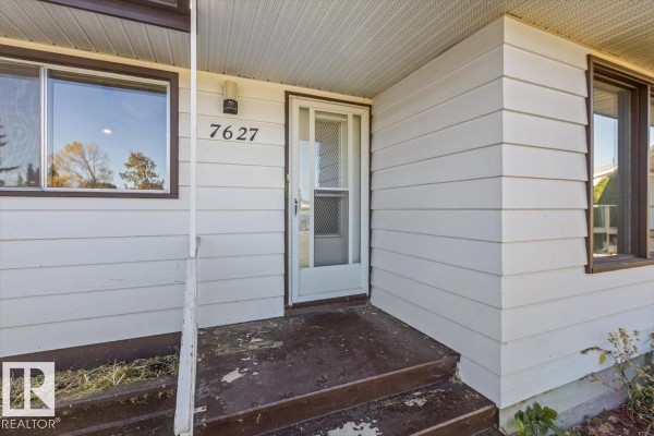 Close-up of the front door and entrance of a white clapboard house. - 7627 128a Av Nw, Edmonton