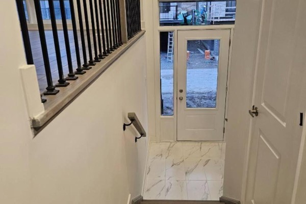 Interior view looking towards the front door with marble-look tile flooring and white walls. - 763 Stanstead Path, Oshawa