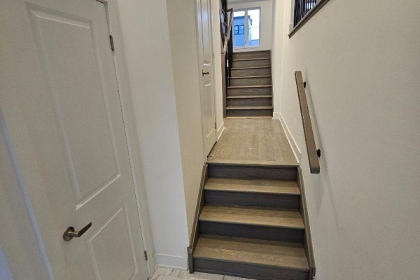 Interior hallway with white doors, marble-look tile, and oak-look stairs leading up. - 763 Stanstead Path, Oshawa