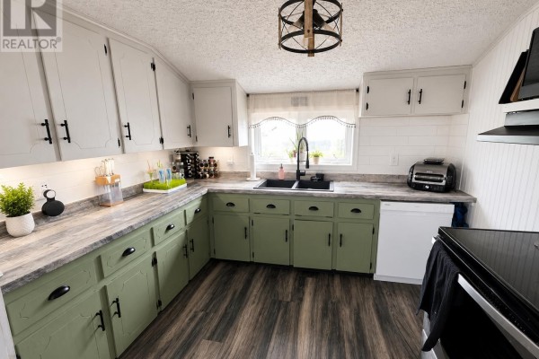 Kitchen with green lower cabinets, white upper cabinets, subway tile backsplash, and a window over the sink. - 764 Harper Road, Peterville