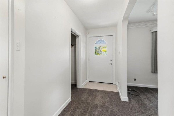 Interior entryway with gray carpet, white walls, and a white door with glass panes. - 765 Oakenwald Avenue, Winnipeg