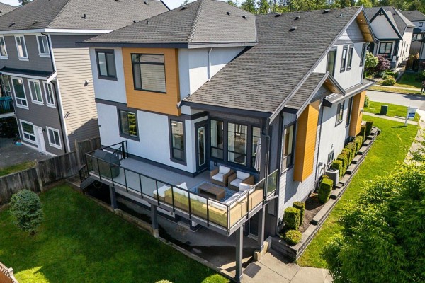 Aerial view of a house back deck with glass railings and outdoor furniture. - 7667 155 Street, Surrey