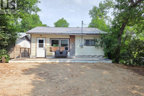 Front exterior view of the beige cottage with a covered porch and gravel driveway. - 769 Ennis Avenue, White Bear Ir 70