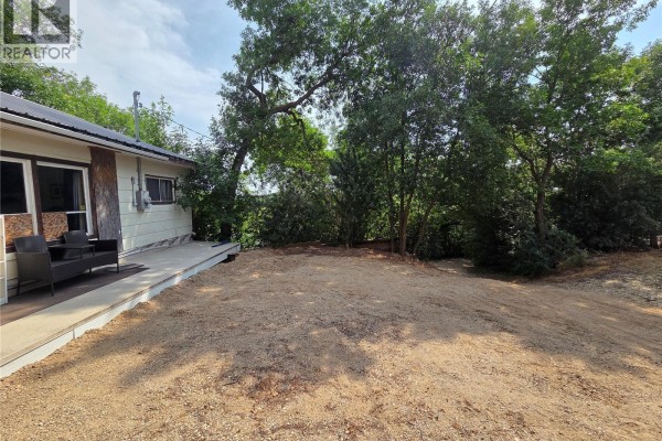 Gravel area and trees to the side of the cottage, showing the natural setting. - 769 Ennis Avenue, White Bear Ir 70