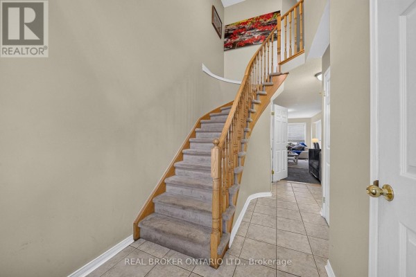 Interior staircase with grey carpet treads, wooden railings, and beige walls leading to upper floor. - 77 - 800 Paramount Drive, Hamilton