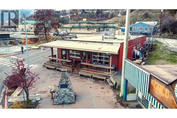 Aerial view of a red commercial building with outdoor seating and signage. - 77 8th Avenue, Lillooet