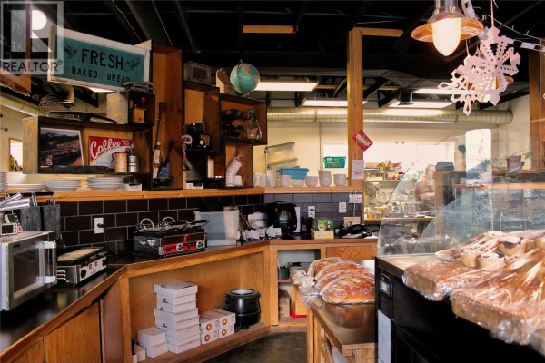 Interior view of a counter with baked goods, coffee station, and display cases. - 77 8th Avenue, Lillooet
