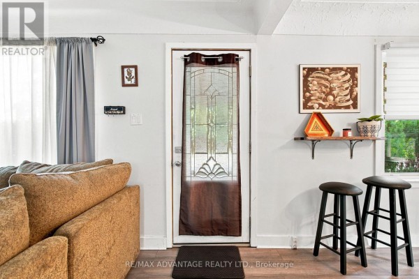Interior view of the front door with a glass insert, a couch on the left, and two stools on the right. - 77 First Avenue, St  Thomas