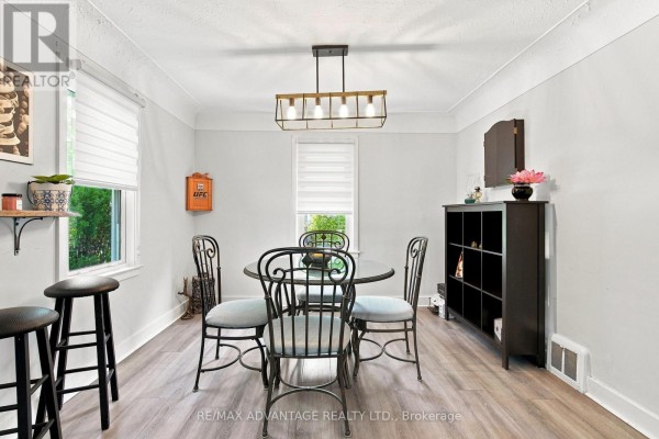 Interior dining room with a round table, four chairs, a black cabinet, and a modern chandelier. - 77 First Avenue, St  Thomas