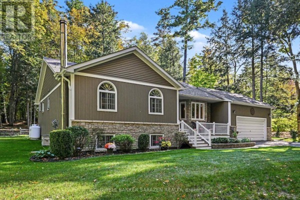 Side view of a bungalow with brown siding, stone foundation, and surrounding mature trees. - 77 Lorlei Drive, Mcnab/braeside