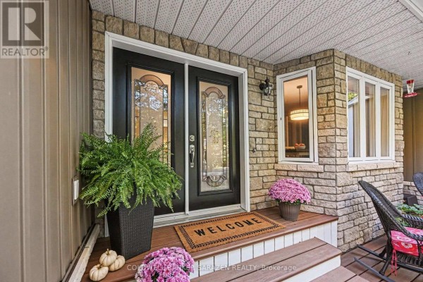 Close-up of the front entrance with a double glass door, stone detailing, and porch plants. - 77 Lorlei Drive, Mcnab/braeside