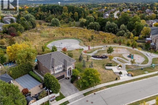 Aerial view of a large residential house adjacent to a park and playground. - 77 Newcombe Road, Dundas