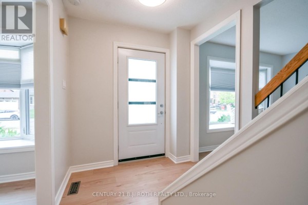 Interior entryway with light wood floors, white trim, and a view into adjacent rooms. - 77 Pepler Place, Barrie