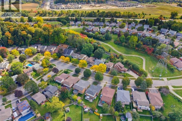 Aerial view of a suburban neighborhood with mature trees and fall foliage. - 77 Yellow Birch Drive, Kitchener