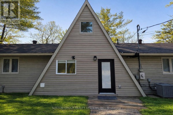 Close-up of the A-frame exterior with a black front door and window details - 7701 Doner Drive, Severn