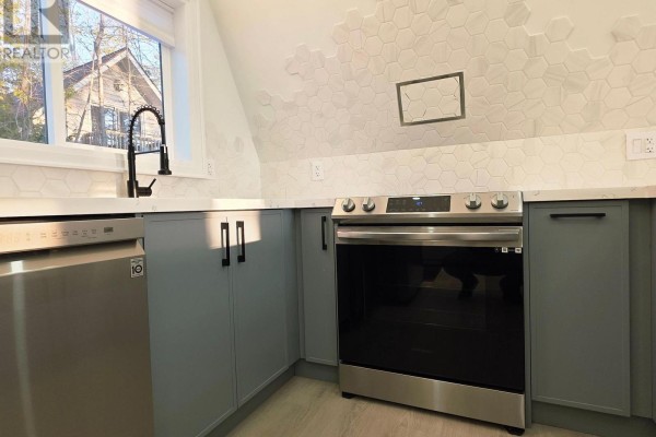 Modern kitchen featuring a large island, stainless steel appliances, and light-colored cabinetry - 7701 Doner Drive, Severn